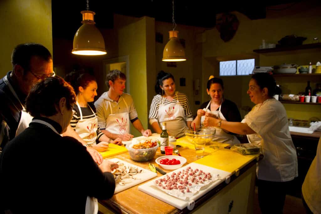 Participants engaged in a cooking class, preparing ingredients at a kitchen counter.
